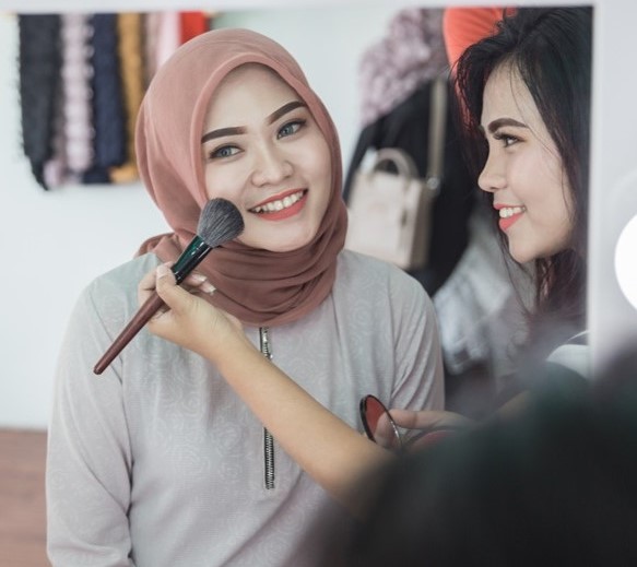 Beauty make up artist applying cosmetic. Girl gets blush on the cheekbones